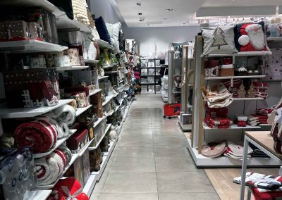 White shelving racks and grey tiled flooring installed in NEXT homeware department stocked with Christmas products