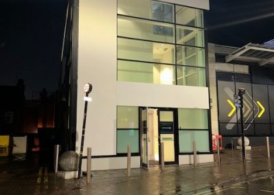 Rendered corner elevation of NEXT store exterior at dusk with lit windows