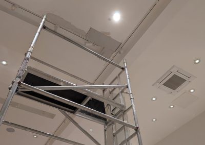 Exposed ceiling void with water-damaged plasterboard stripped back in NEXT store, Trafford