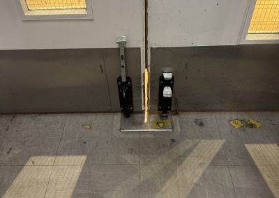Old fire door floor hardware and worn threshold before replacement at Next, Oxford Street, London