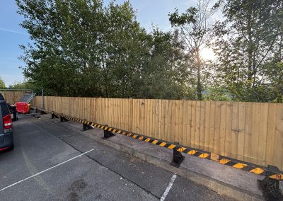 New timber fence with safety barrier in vet surgery car park at sunrise
